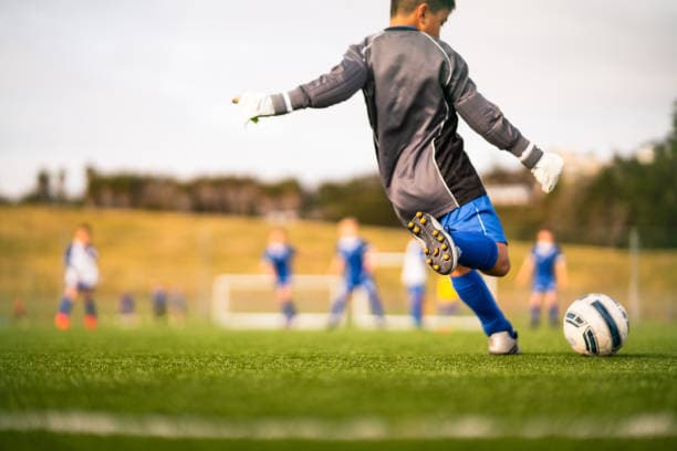 Rebels Soccer player striking the ball